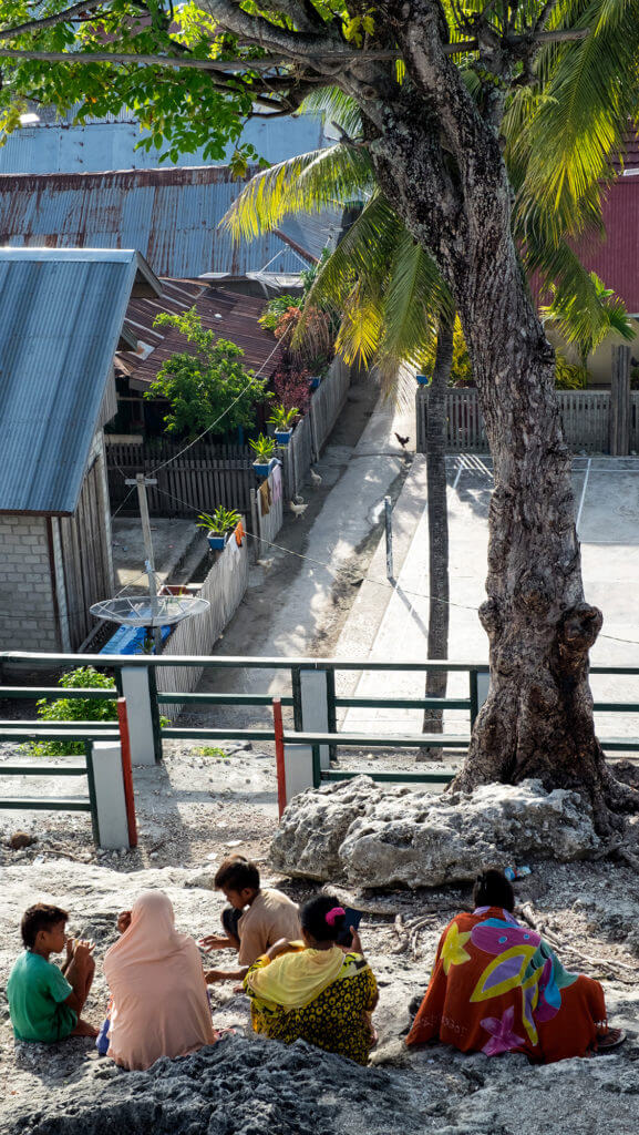 Familia bajau a la sombra de una palmera en las islas Togean de Sulawesi