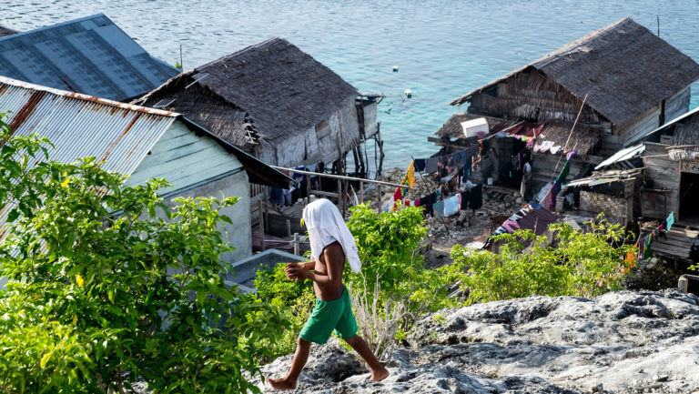 Niño caminando en la aldea bajau de las islas Togean en Sulawesi